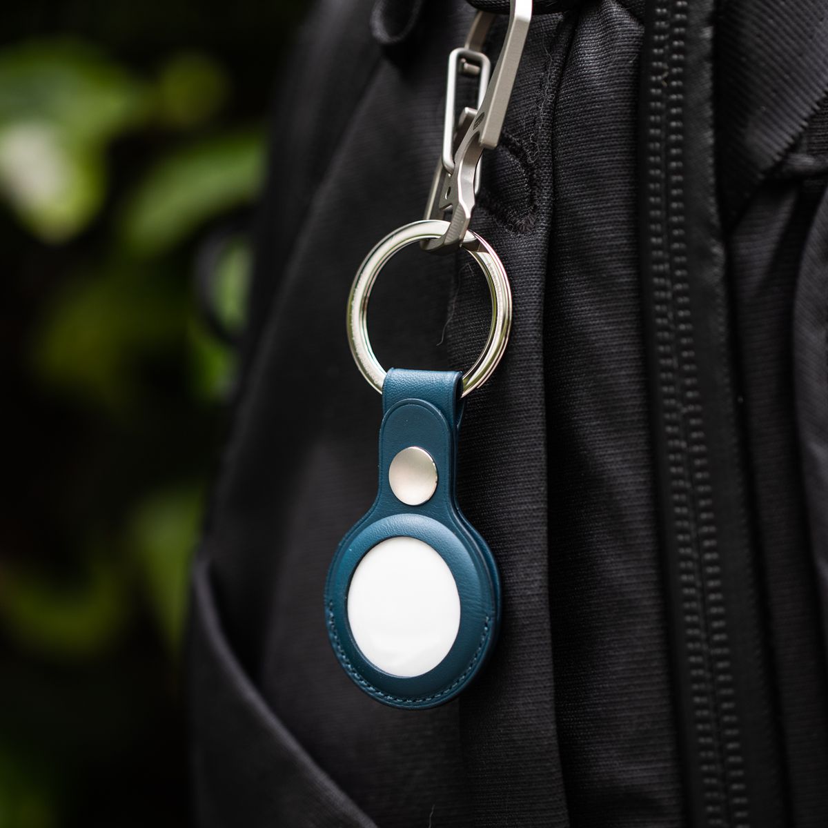 An AirTag in an Apple keychain accessory