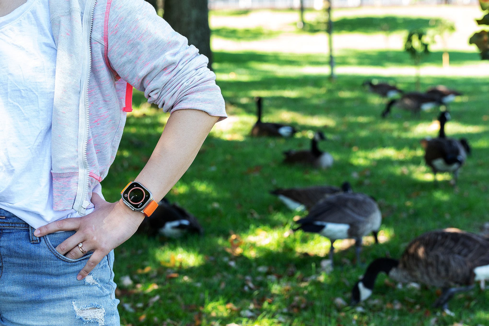 Woman modeling Apple Watch Ultra with geese in the background